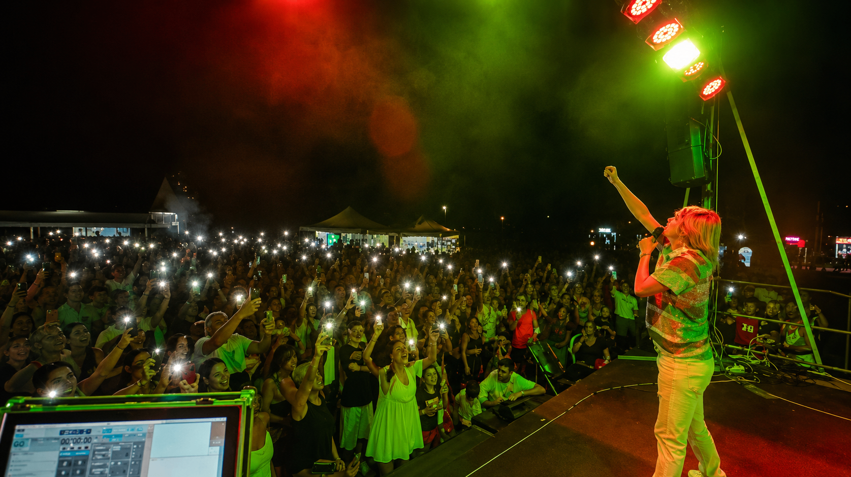 Nino Esposito live sul palco con luci rosse e verdi davanti al pubblico
