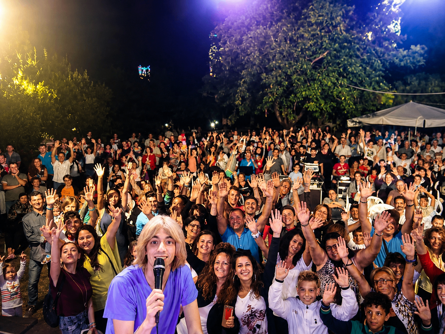 Nino Esposito con microfono davanti a un pubblico festante