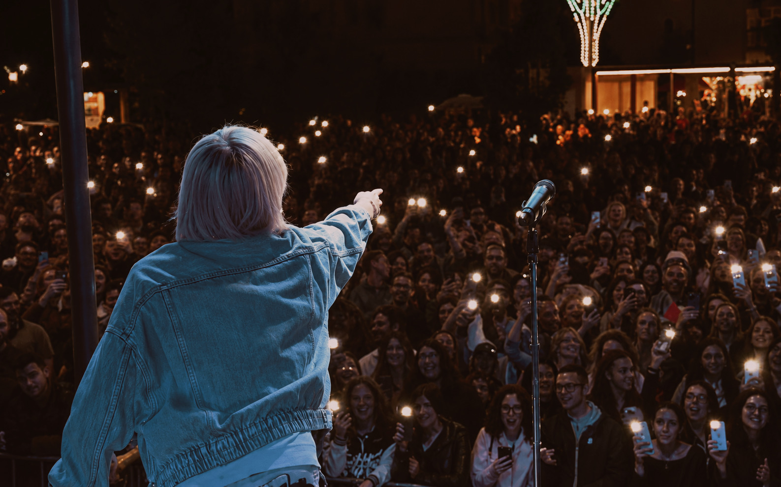 Nino Esposito di spalle sul palco mentre indica il pubblico